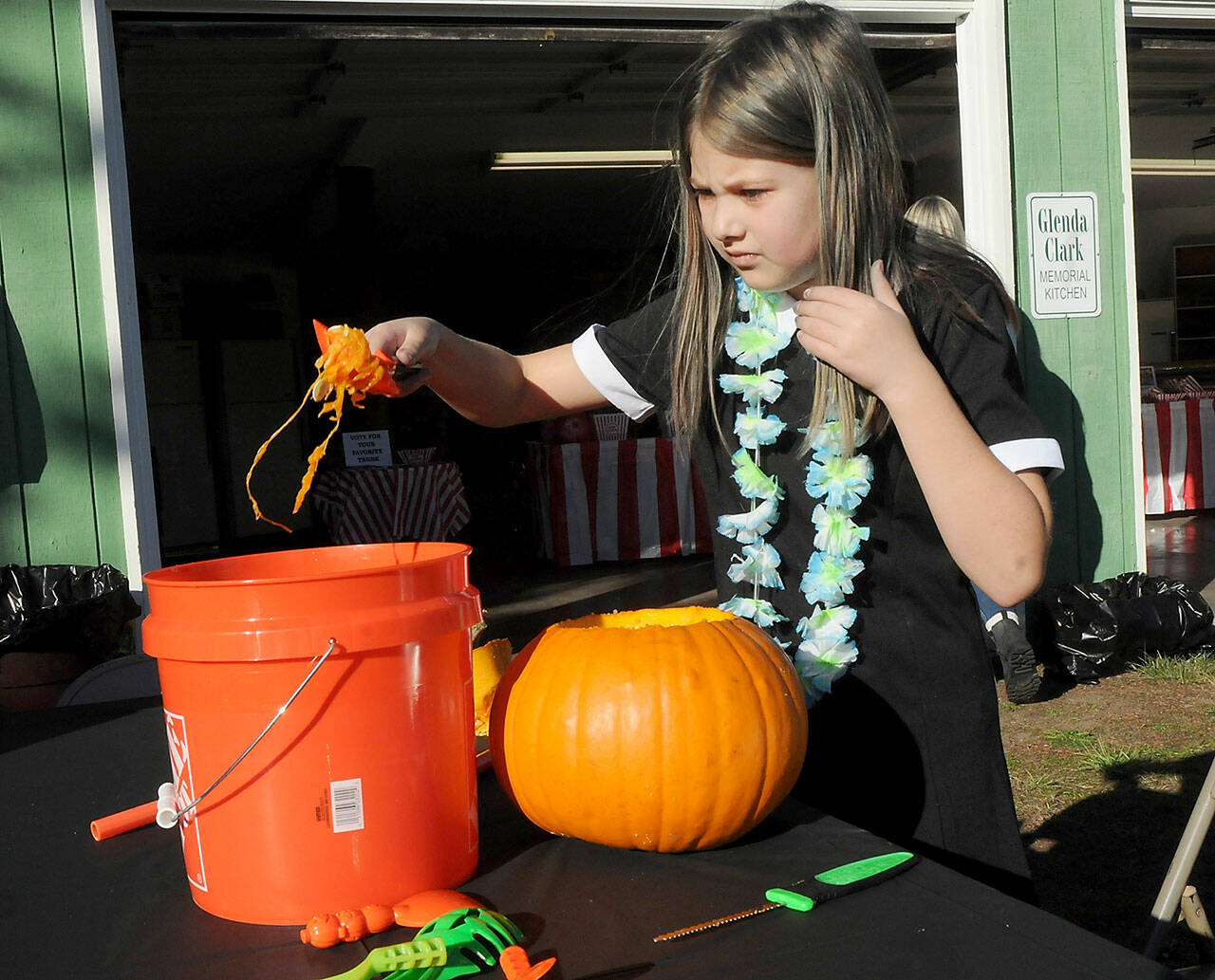 Daria O’Neill, 9, of Sequim empties the innards of a pumpkin at Sequim Prairie Grange Fall Festival & Trunk or Treat on Saturday at the grange hall and grounds near Carlsborg. The festival featured pumpkin carving, children’s games and treats handed out to costumed youngsters. (Keith Thorpe/Peninsula Daily News)