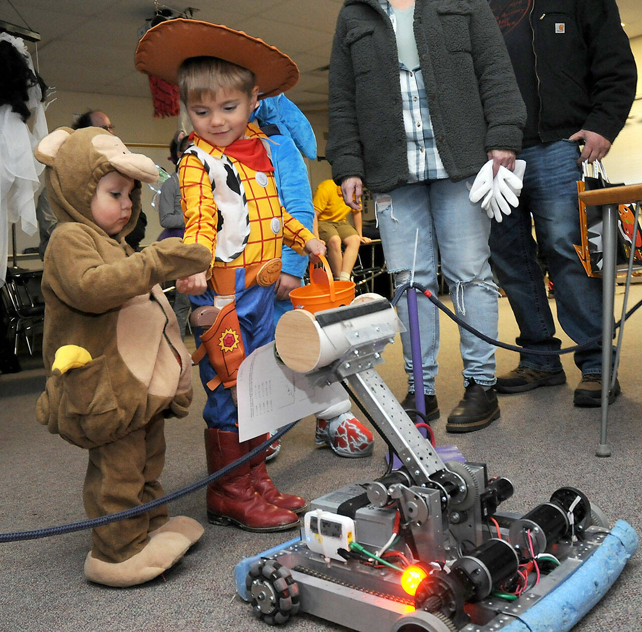 Sequim siblings Jaxson Kober, 2, and Micah Brooks, 4, receive candy offered by a robot created by students in the Sequim High School robotics program during Haunted Hallways on Saturday at the school. Haunted Hallways featured a portion of the school set aside for a variety of Halloween games and attractions hosted by students as a benefit for the Sequim Food Bank. (Keith Thorpe/Peninsula Daily News)