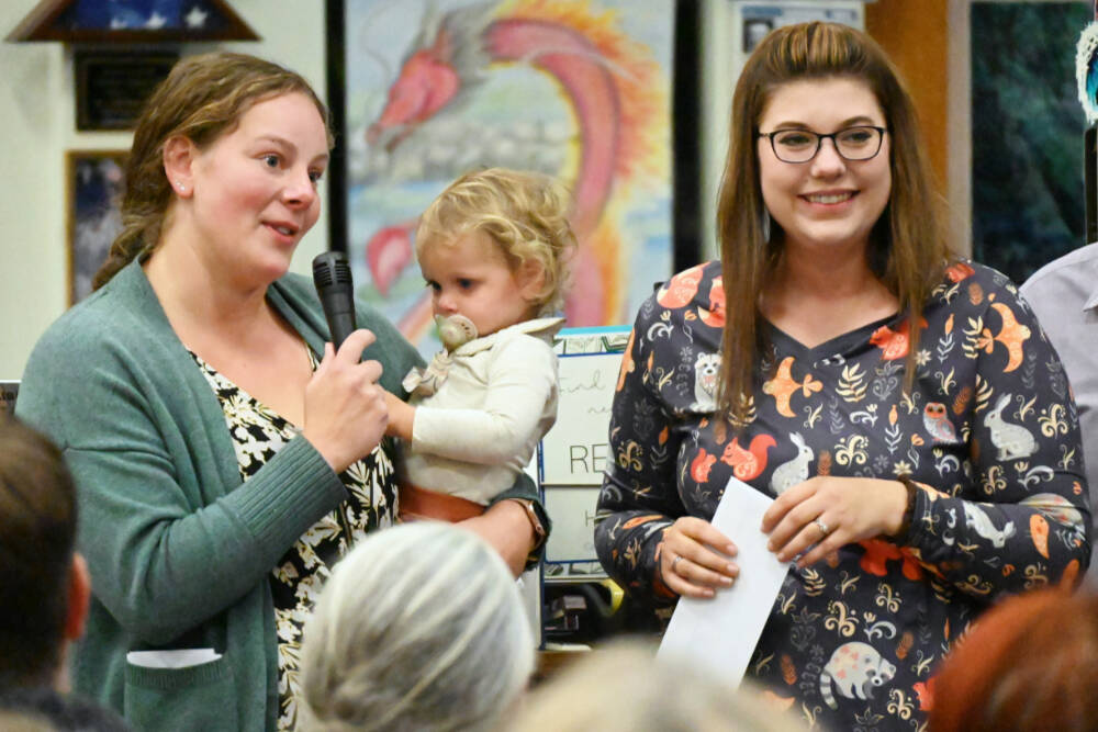 Brianne Lawson, treasurer with Peninsula Pre-3 Cooperative (with 16-month-old Charlie) and fellow board member Kelsey Wheeler accept a $4,150 grant from the Albert Haller Foundation. (Michael Dashiell/Olympic Peninsula News Group)