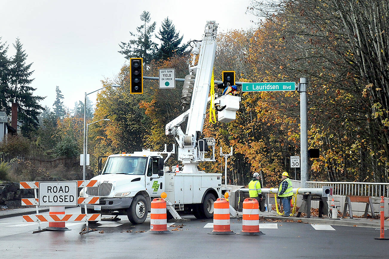 A crew from Olympic Electric Co. works to upgrade a traffic signal at Race Street and Lauridsen Boulevard in Port Angeles on Thursday as part of Phase One of the Race Street Corridor upgrade project. The first part of the project includes a pedestrian trail, improved crosswalks, stormwater infrastructure replacement and landscaping between Eighth Street and Olympus Avenue. (Keith Thorpe/Peninsula Daily News)
