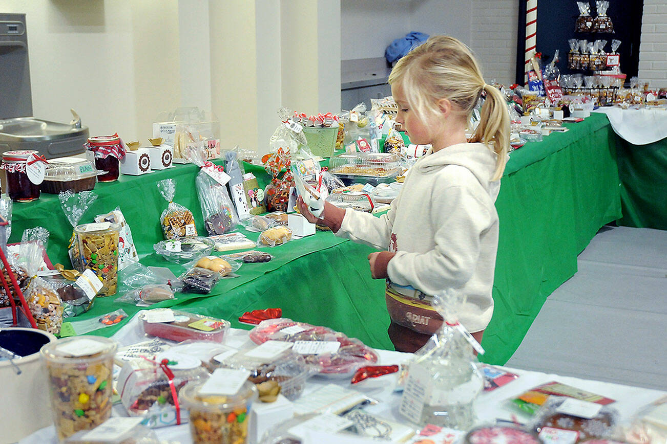 KEITH THORPE/PENINSULA DAILY NEWS 

Six-year-old Baylee Spence of Port Angeles looks over holiday confections at the Original Christmas Cottage craft and gift fair on Friday at Vern Burton Community Center, 308 E. Fourth St., in Port Angeles. The annual three-day fair features thousands of holiday gifts and decorations created by North Olympic Peninsula artisans. It continues Saturday from 9 a.m. to 6 p.m. and Sunday from 10 a.m. to 4 p.m.