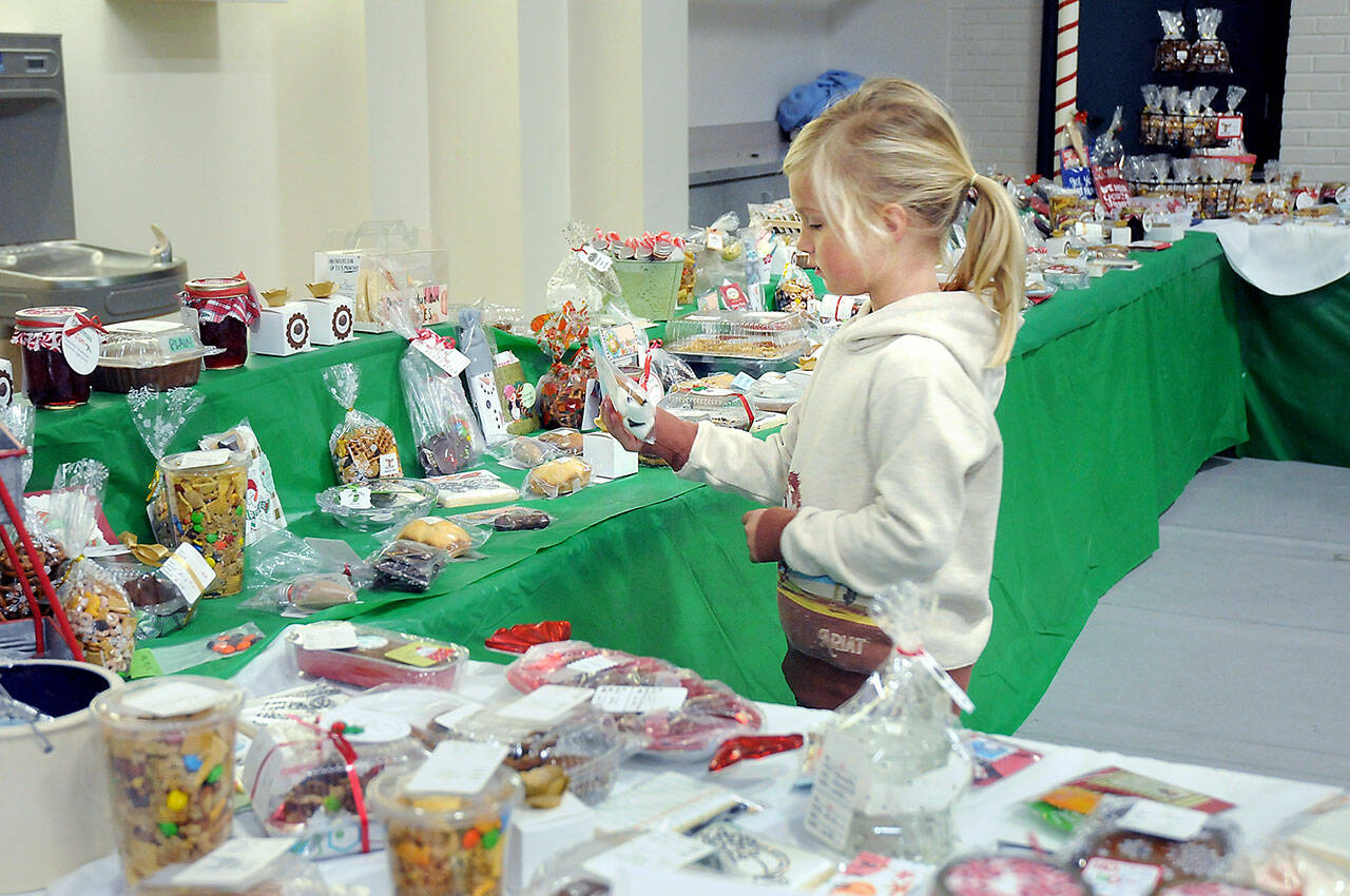 Six-year-old Baylee Spence of Port Angeles looks over holiday confections at the Original Christmas Cottage craft and gift fair on Friday at Vern Burton Community Center, 308 E. Fourth St., in Port Angeles. The annual three-day fair features thousands of holiday gifts and decorations created by North Olympic Peninsula artisans. It continues Saturday from 9 a.m. to 6 p.m. and Sunday from 10 a.m. to 4 p.m. (KEITH THORPE/PENINSULA DAILY NEWS)