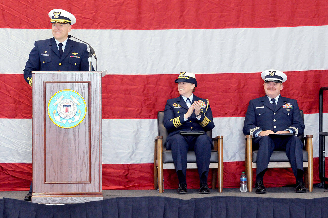 Cmdr. Brent Schmadeke, commanding officer of U.S. Coast Guard Air Station/Sector Field Office Port Angeles, left, introduces keynote speaker Capt. Holly Harrison of Coast Guard District 13, center, as Chaplain Mike VanProyen looks on during Saturday’s Veterans Day program in Port Angeles. (Keith Thorpe/Peninsula Daily News)