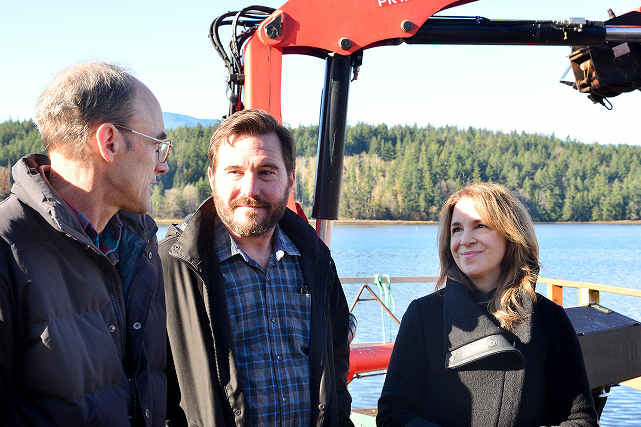 Celebrating the expansion of the Dabob Bay Natural Area by adding 671 acres to the state’s new carbon sequestration program are, from left, Peter Bahls, Northwest Watershed Institute executive director; Jefferson County Commissioner Greg Brotherton; and state Commissioner of Public Lands Hilary Franz at an oyster farm on Dabob Bay. (Peter Segall/Peninsula Daily News)