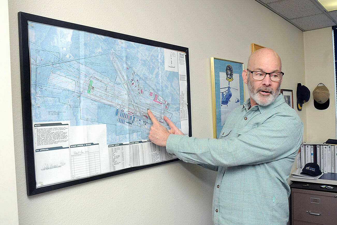 Jon Picker, airport and marina manager for the Port of Port Angeles, describes runway sections for William R. Fairchild International Airport on a diagram of the terminal area. (Keith Thorpe/Peninsula Daily News)