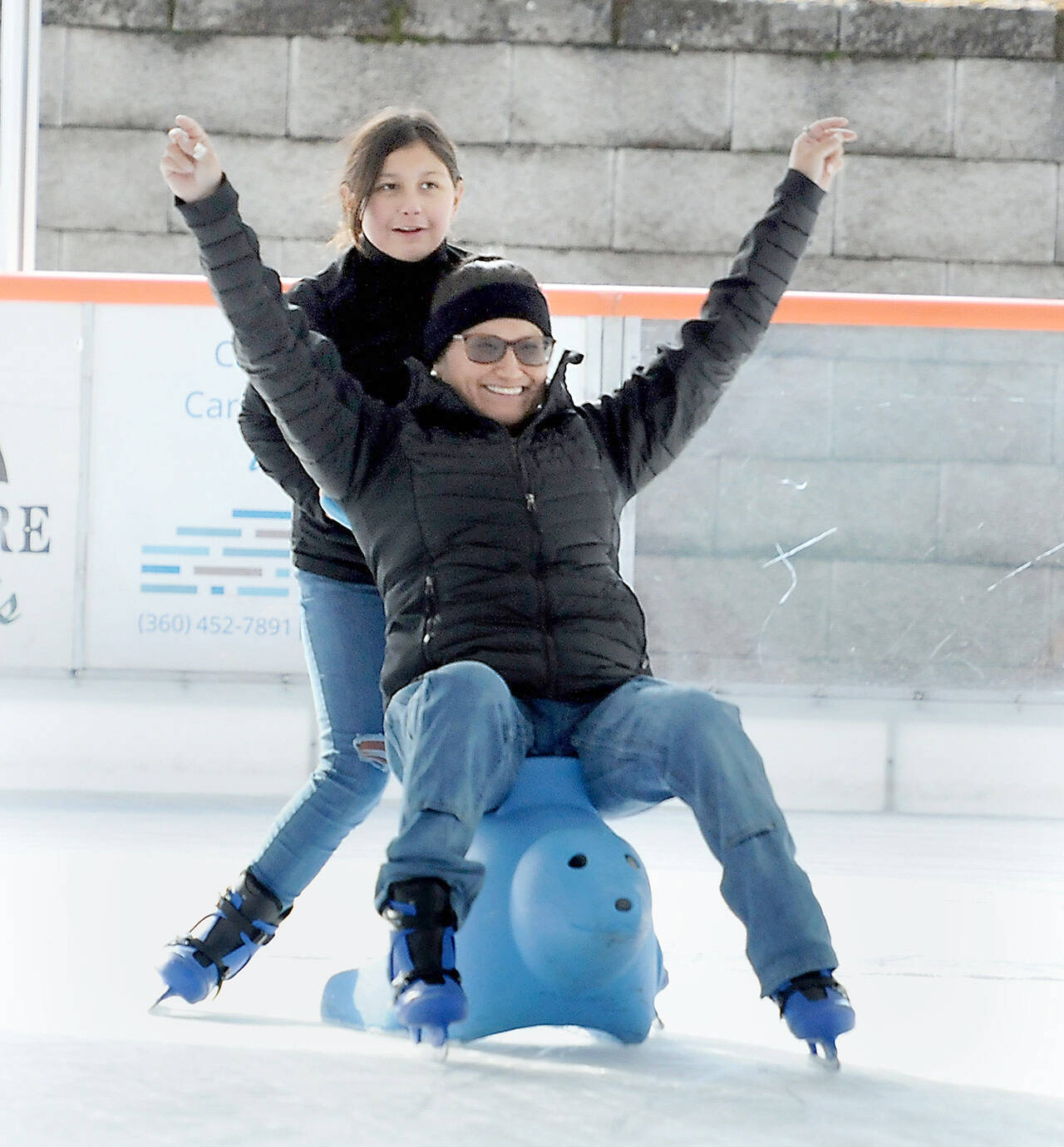 Sharmaine Wright of Port Angeles expresses delight while being pushed by her daughter, Kaylee Konopaski, 10, on the ice at the Port Angeles Winter Ice Village on Saturday. The village, which features a temporary ice skating rink, opened Friday and will operate daily from noon to 9 p.m. through Jan. 2. (Keith Thorpe/Peninsula Daily News)