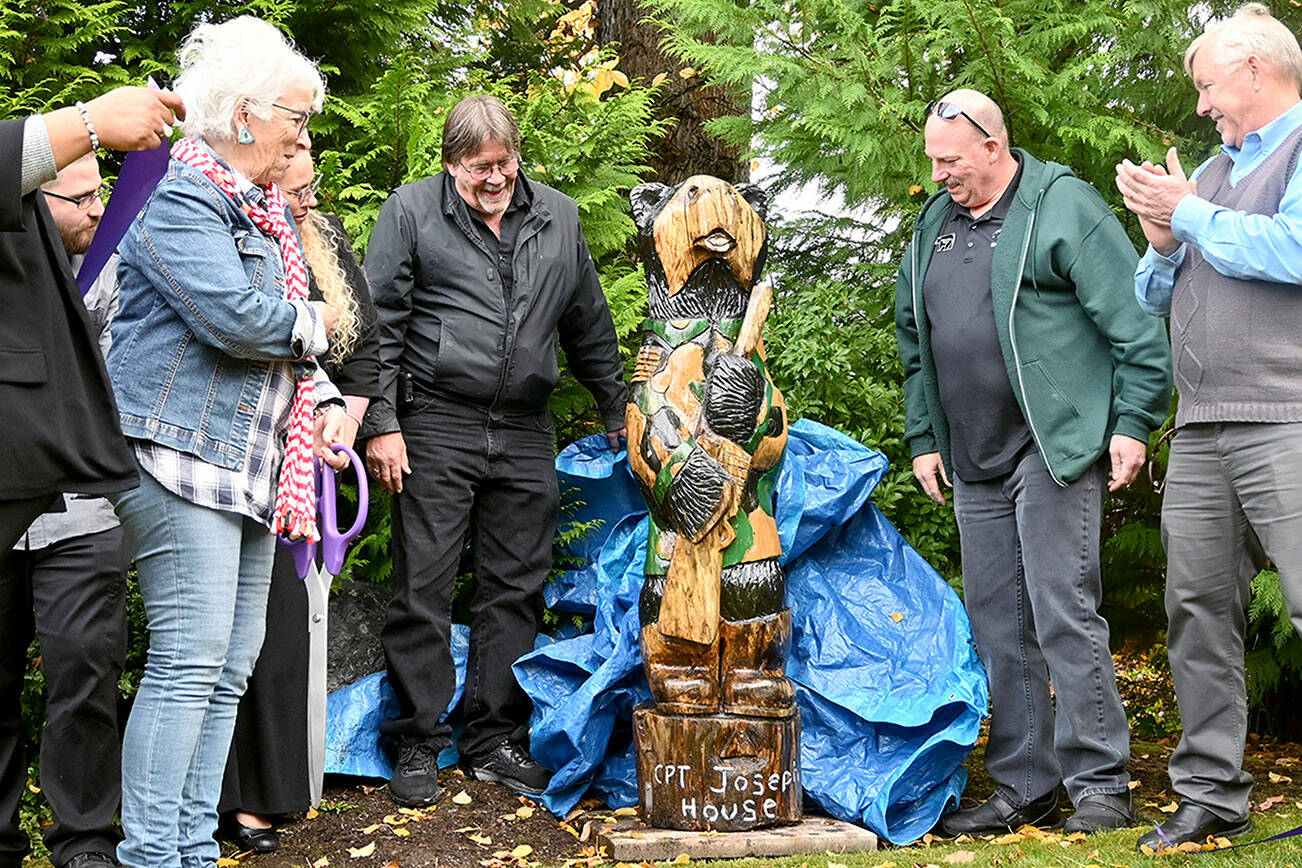 Betsy Reed Schultz (far left), founder of Captain Joseph House, gets a look at a carved bear donated by Bret Wirta’s Black Bear Diner and Holiday Inn & Suites last week at the Port Angeles facility. (Michael Dashiell/Olympic Peninsula News Group)