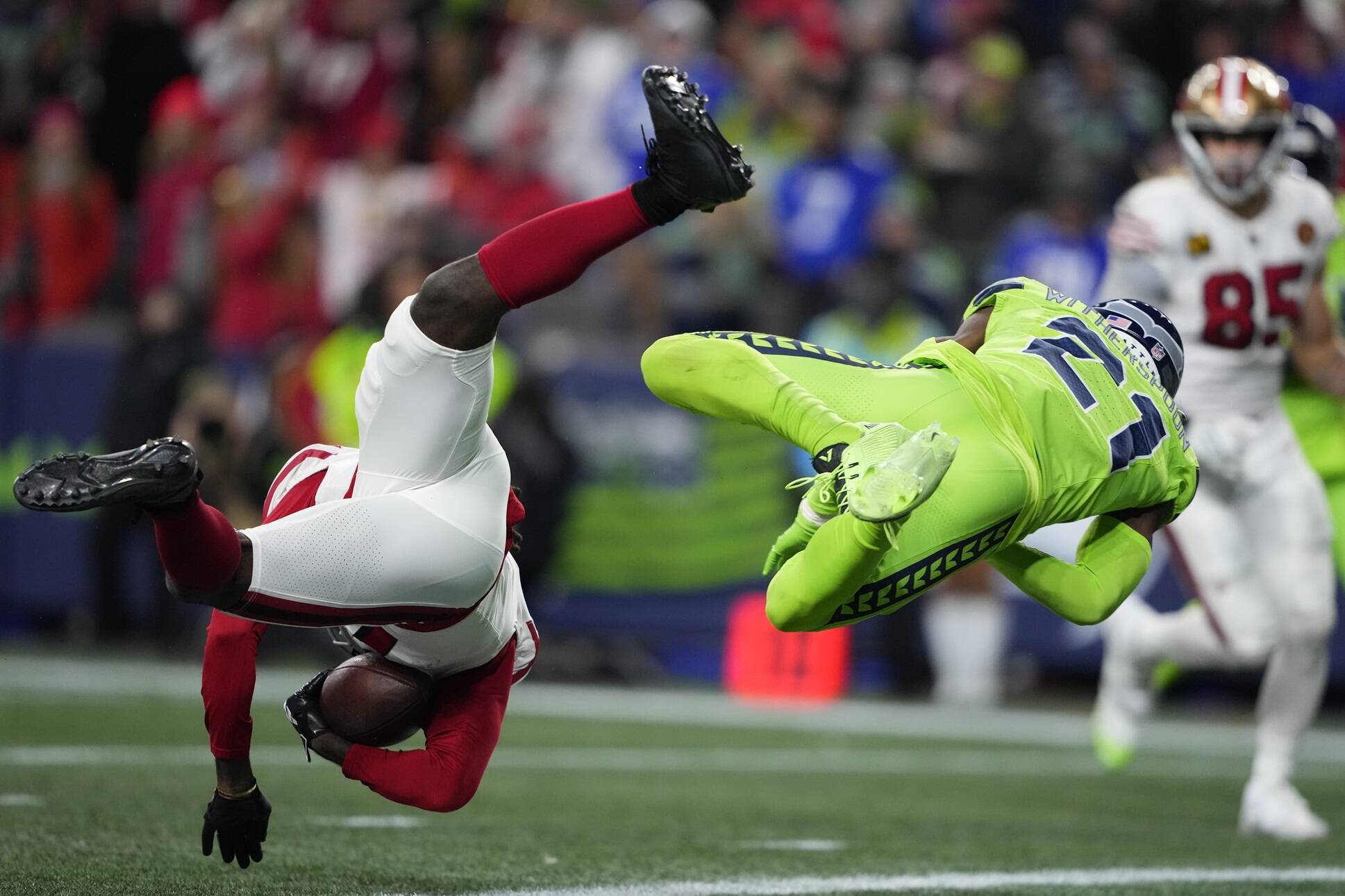 San Francisco 49ers wide receiver Brandon Aiyuk, left, defended by Seattle Seahawks cornerback Devon Witherspoon (21) catches a 28-yard pass for a touchdown during the second half of an NFL football game, Thursday, Nov. 23, 2023, in Seattle. (AP Photo/Lindsey Wasson)