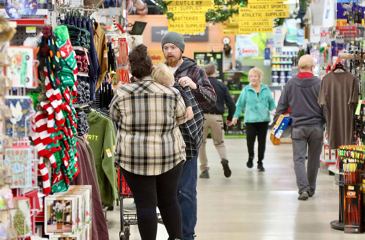 Shoppers look for bargains at Swain’s General Store in Port Angeles on Friday morning. On the left is Shawn Fowler, his wife Amber and their sleeping 2-year-old Cash. (Dave Logan/for Peninsula Daily News)