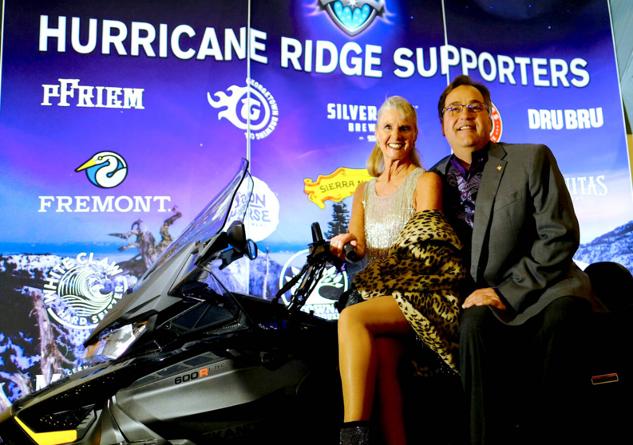 Crystal Stout and Greg Bondy pose on a snowmobile that was purchased through funds raised at Winterfest 2022. (Greg Birch)