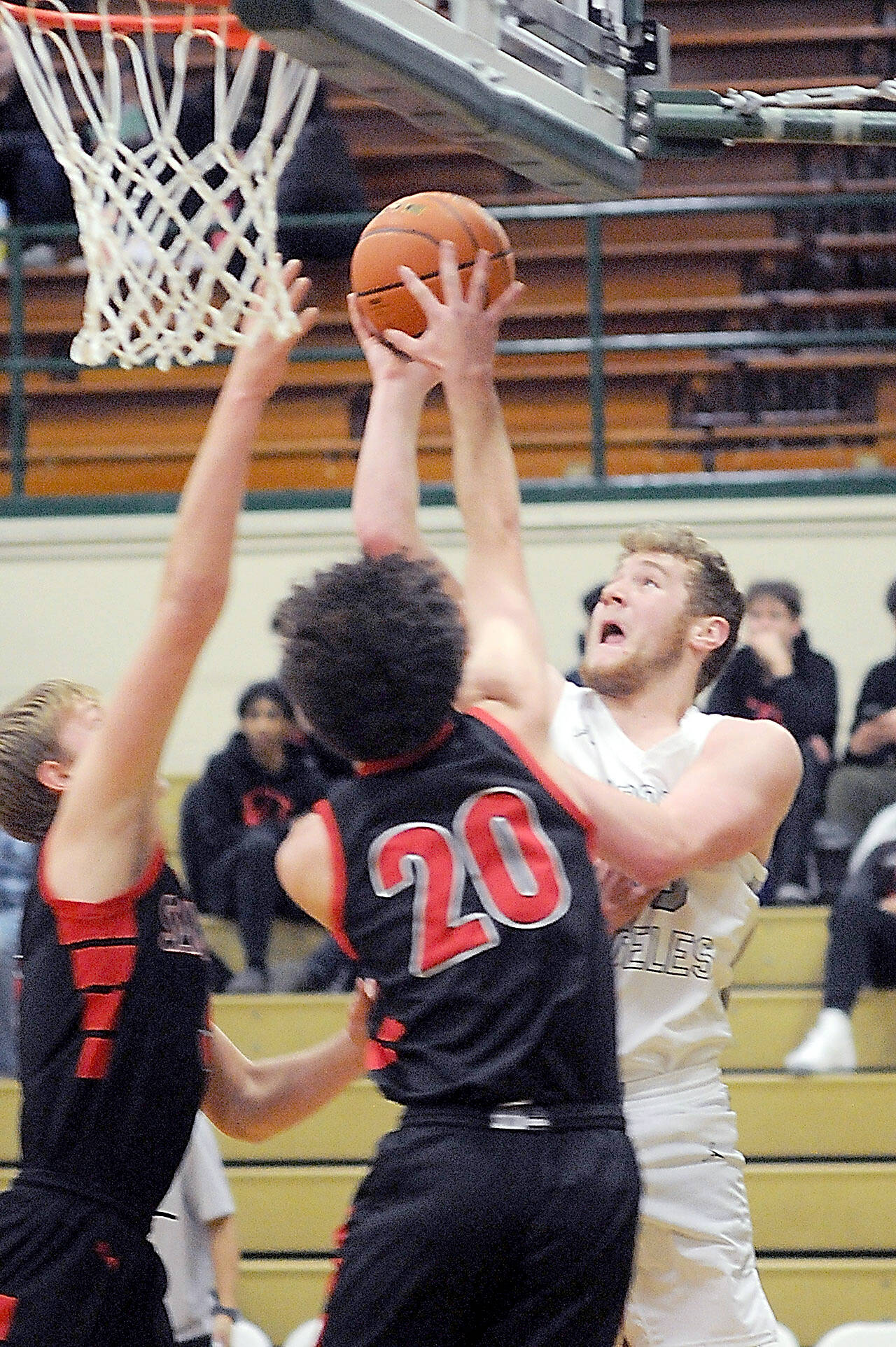 Port Angeles’ Isiah Shamp, right, pushes for the hoop over the defense of Sammamish’s Barry Morrissette, left, and Hudson Reed on Wednesday in Port Angeles. (Keith Thorpe/Peninsula Daily News)