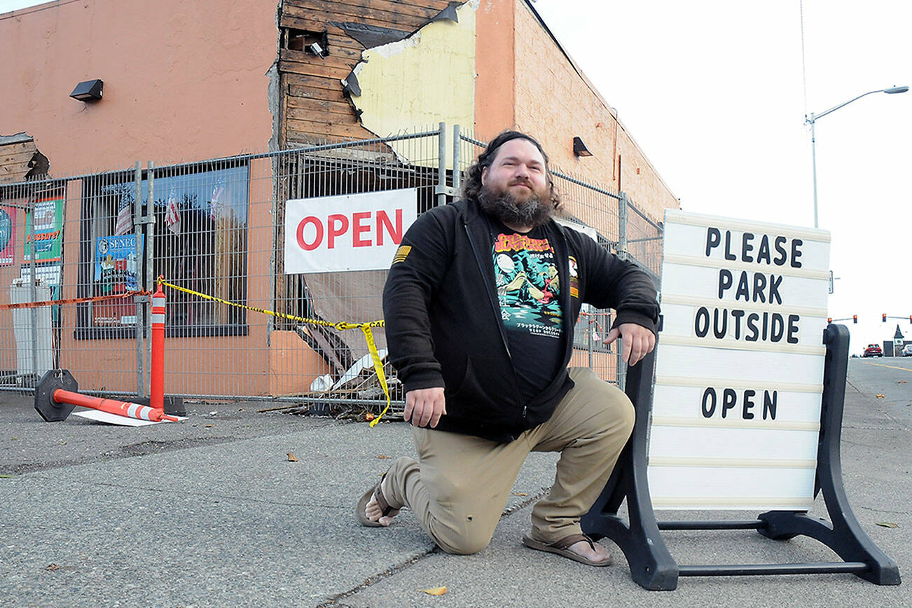 KEITH THORPE/PENINSULA DAILY NEWS
Justin Brophy, general manager of the Northwest Tobacco Emporium in Port Angeles, shows off a readerboard on Friday that takes a light-hearted view of the business' situation.