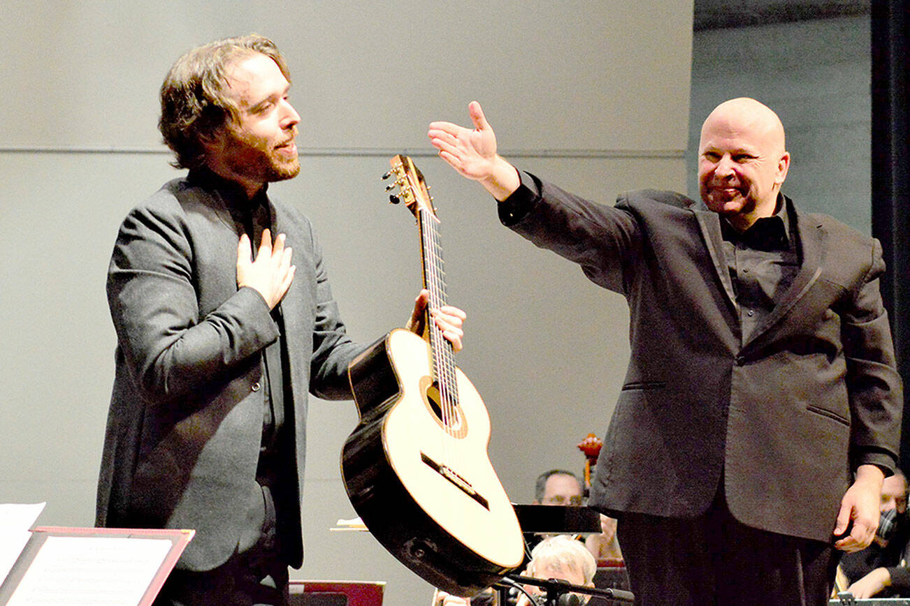 Guitarist Colin Davin, left, stands beside Port Angeles Symphony conductor Jonathan Pasternack, after stepping in at the last minute to perform with the orchestra in December 2021. Davin will rejoin the symphony for its Holiday Concert this Saturday. (Diane Urbani de la Paz/for Peninsula Daily News)