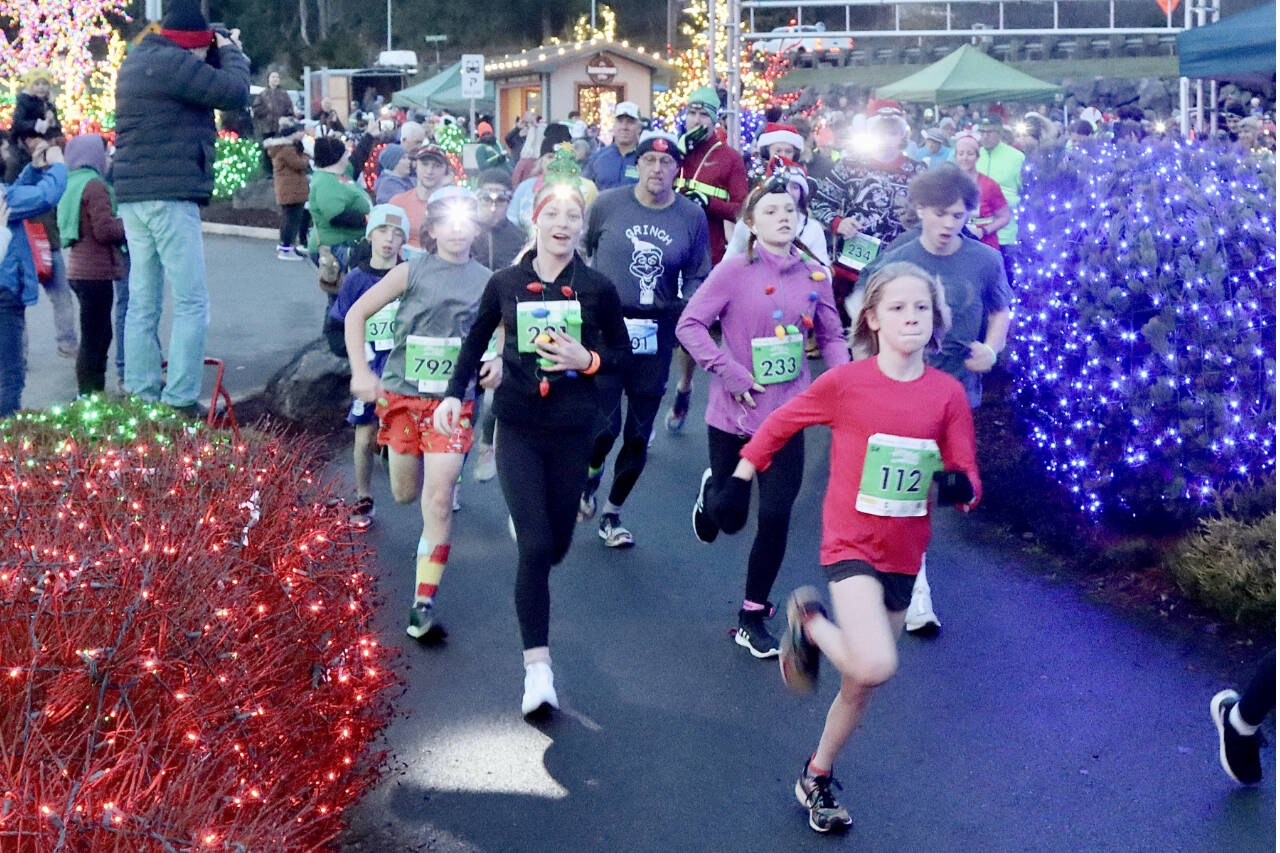 Eleanor Jones, 11, of Sequim (No. 112) leads the pack at the beginning of the Run the Peninsula’s Jamestown Glow Run in Blyn late Saturday afternoon. Jones won the women’s 5K as more than 450 runners participated. (Dave Logan/for Peninsula Daily News)
