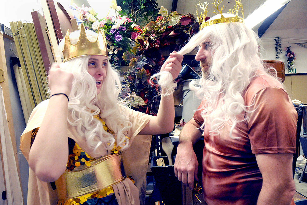 Emily McAlily, in the part of Chandon, left, toys with the wig of Steve Methner, playing the role of King Triton, prior to a Tuesday rehearsal of the PA Panto production of Ethel Mermaid and the Varying Degrees of Evil, which starts this weekend at Peninsula College. (Keith Thorpe/Peninsula Daily News)