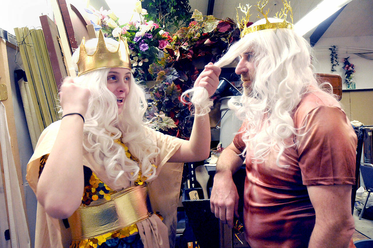 Emily McAlily, in the part of Chandon, left, toys with the wig of Steve Methner, playing the role of King Triton, prior to a Tuesday rehearsal of the PA Panto production of Ethel Mermaid and the Varying Degrees of Evil, which starts this weekend at Peninsula College. (Keith Thorpe/Peninsula Daily News)