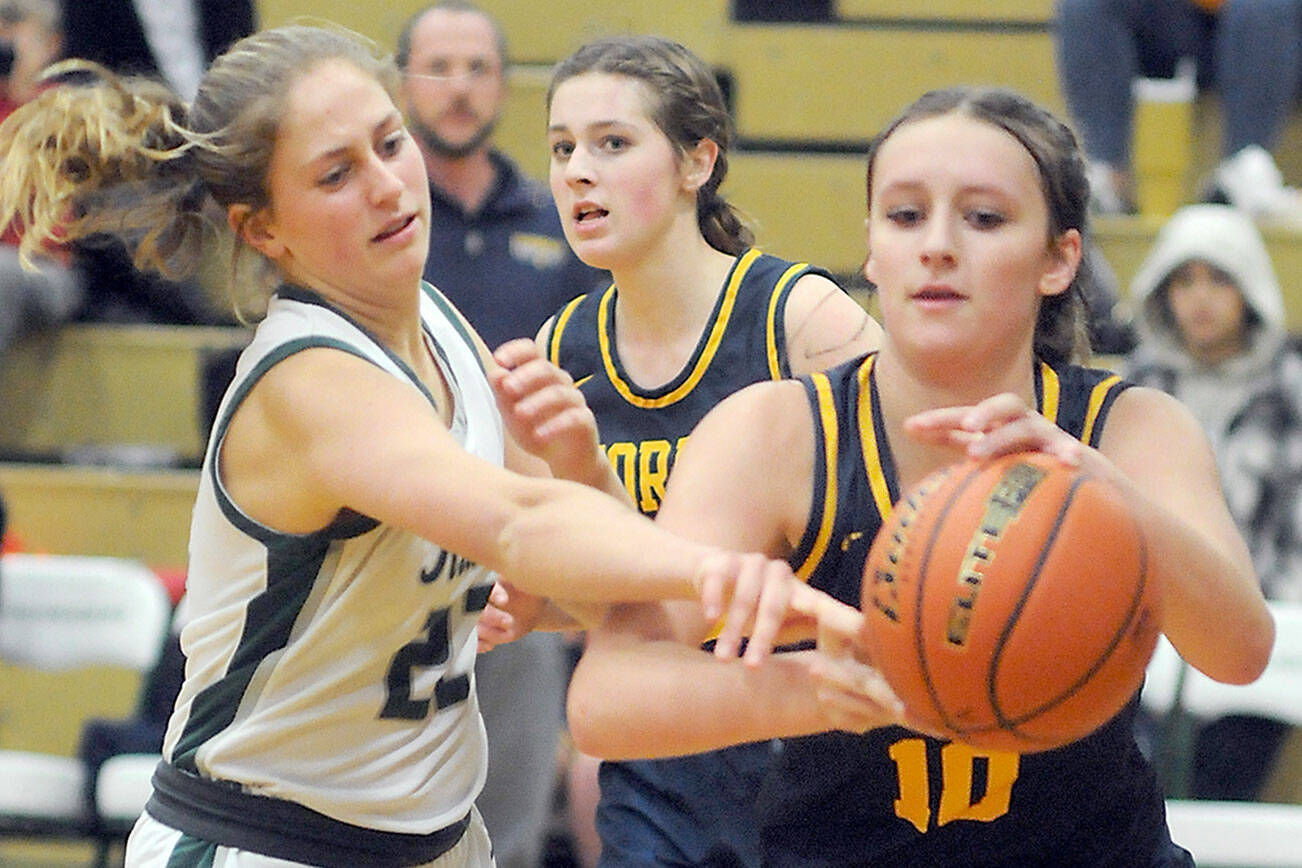 Forks’ Bailey Johnson, right, drives along the baseline as teammate Fynlie Peters, left, defends against Port Angeles’ Morgan Politika last week in Port Angeles. (Keith Thorpe/Peninsula Daily News)