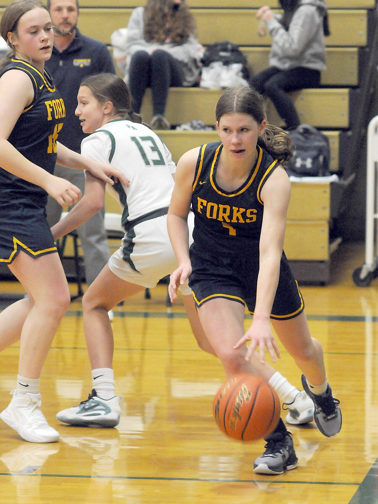 Forks Bailey Johnson, right, drives along the baseline as teammate Fynlie Peters, left, defends against Port Angeles Morgan Politika last week in Port Angeles. (Keith Thorpe/Peninsula Daily News)