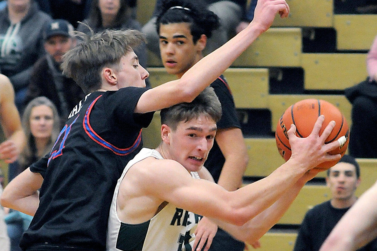 Port Angeles’ Josiah Long, right, tries to escape the defense of East Jefferson’s 6-foot-8 Stuart Dow in a game last year in in Port Angeles. Dow had eight blocks in his first game this year. (Keith Thorpe/Peninsula Daily News)