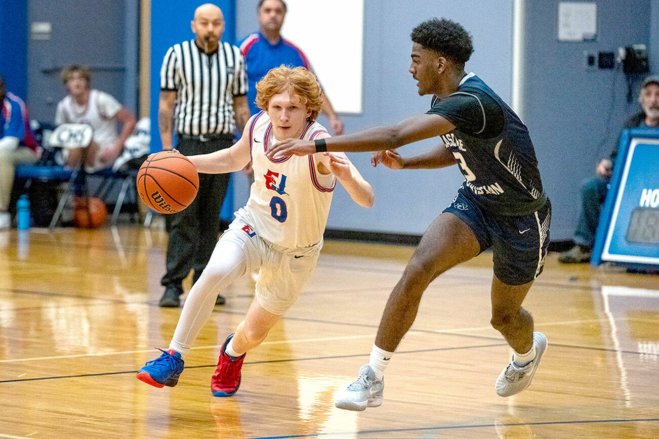 Steve Mullensky/for Peninsula Daily News

Rivals' Tracycen Brown, #3, gets around the block of Cascade Christian's Josiah Gopaul during a Thursday night home game played in Chimacum.