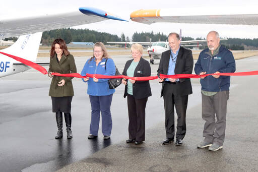 From left to right, Port of Port Angeles Commissioner Colleen McAleer, Ann Richart, the aviation director for the state Department of Transportation, Port Commissioner Connie Beauvais, Ryan Zulaul and Port Commissioner Steve Burke cut a ceremonial ribbon on Tuesday at Fairchild International Airport to celebrate the resurfacing of the runway. (Dave Logan/for Peninsula Daily News)