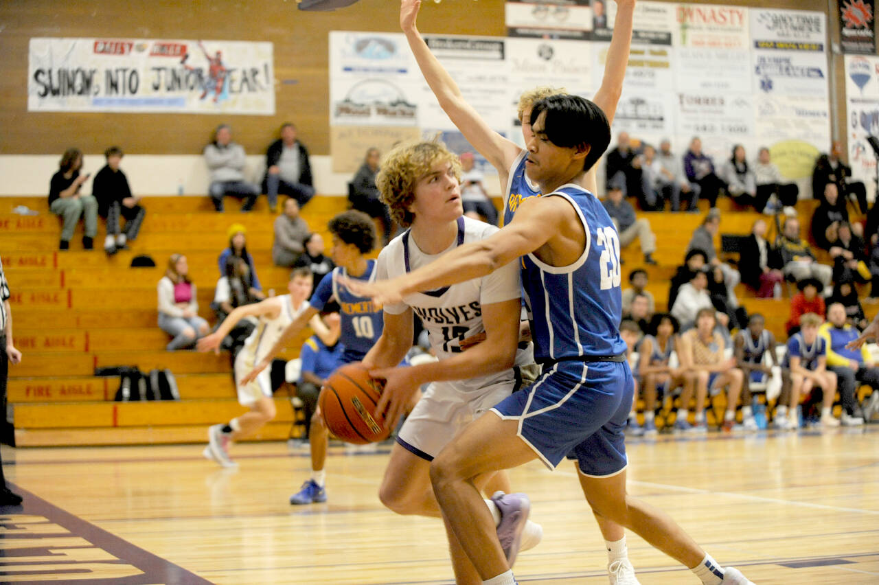 Sequim’s Zeke Schmadeke (15) is guarded tightly by Bremerton’s Isaiah Cadengo (20) on Tuesday night in Sequim. Bremerton won the closely fought contest 69-66. (Matthew Nash/Olympic Peninsula News Group)