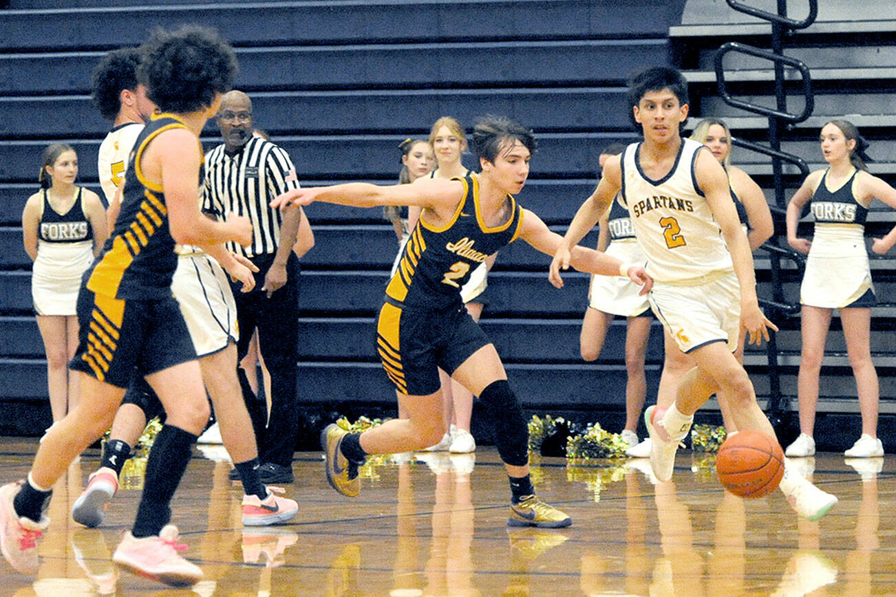 Forks’ Aidan Salazar drives up court against the Ilwaco defense on Wednesday night in the Spartan Gym where the Fishermen came from behind in the second half to defeat the Spartant 64-41. (Lonnie Archibald/for Peninsula Daily News)