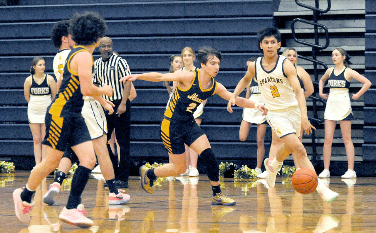 Forks’ Aidan Salazar drives up court against the Ilwaco defense on Wednesday night in the Spartan Gym where the Fishermen came from behind in the second half to defeat the Spartant 64-41. (Lonnie Archibald/for Peninsula Daily News)