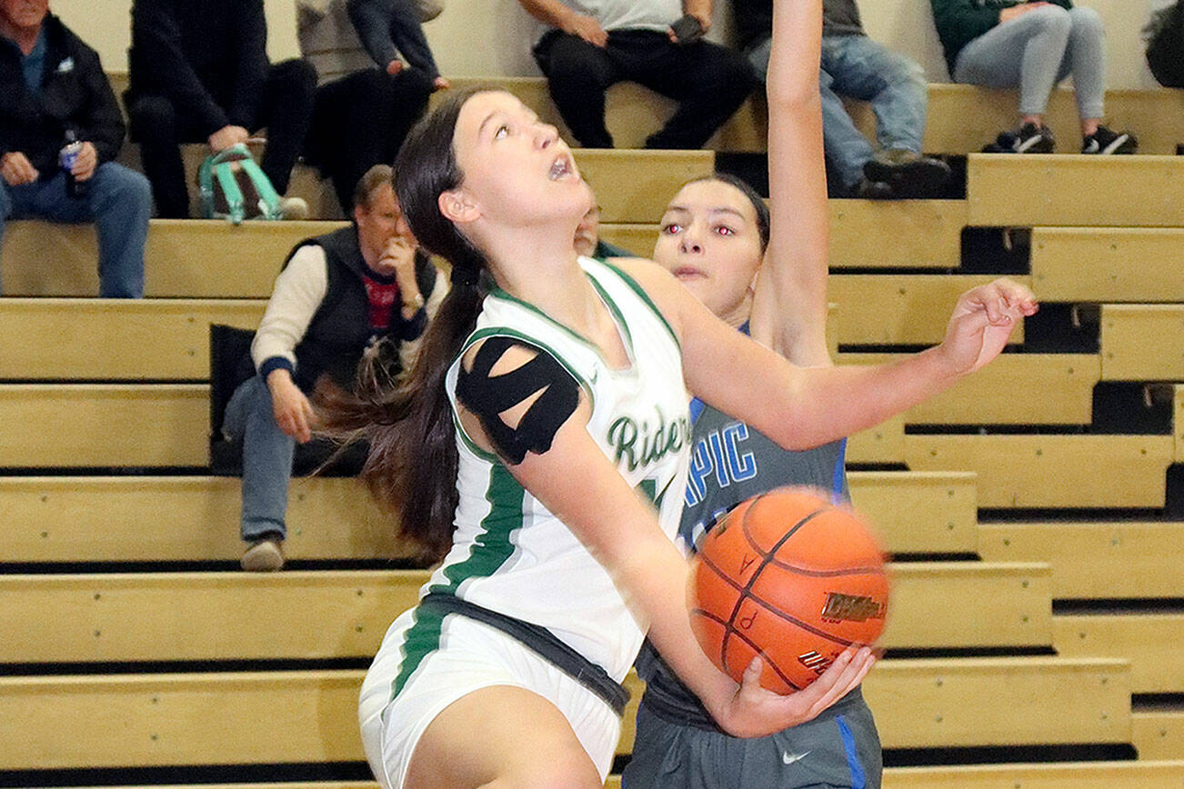 Dave Logan/for Peninsula Daily News
Port Angeles' Lindsay Smith attempts a reverse layup during the Roughriders' 59-29 win over Olympic on Thursday in the Rider Gymnasium.
