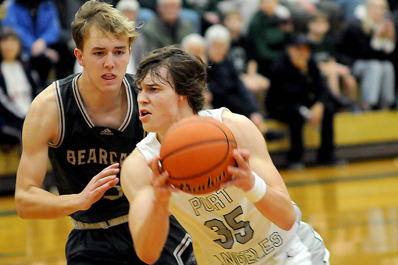 Port Angeles’ Parker Nickerson, right, charges past W.F. West’s Weston Potter during Tuesday’s game at Port Angeles High School. (Keith Thorpe/Peninsula Daily News)