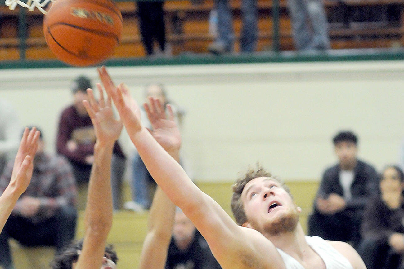Port Angeles’ Isaiah Shamp, right, goes for the quick layup over the head of Enumclaw’s Austin Pierce on Wednesday at Port Angeles High School. (Keith Thorpe/Peninsula Daily News)
