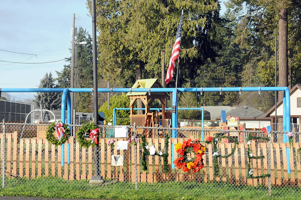 Wreathes, personal notes and flowers adorn the fence outside the Dream Playground at Erickson Playfield in Port Angeles on Tuesday after much of the playground was destroyed by fire last week. (Keith Thorpe/Peninsula Daily News)