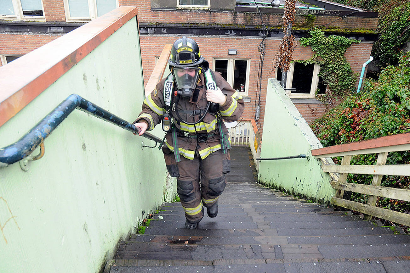 Clallam County Fire District 2 firefighter/EMT Anaka Hughes makes her way up the stairs behind the Conrad Dyar Memorial Fountain in Port Angeles on Saturday to gather donations and pledges supporting the upcoming Leukemia & Lymphoma Society Firefighter Stairclimb on March 10 at the Columbia Center in Seattle. The North Olympic Firefighters Team consisting of firefighters from Fire District 2 and the Port Angeles Fire Department will join about 2,000 firefighters from across the region in the event, ascending 69 floors with 1,356 steps of Seattle’s tallest skyscraper benefiting blood cancer research and patient services. The North Olympic team plans another fundraising event with stairclimb machines on March 10 at Bourbon West, 125 W. Front St. in Port Angeles. (Keith Thorpe/Peninsula Daily News)