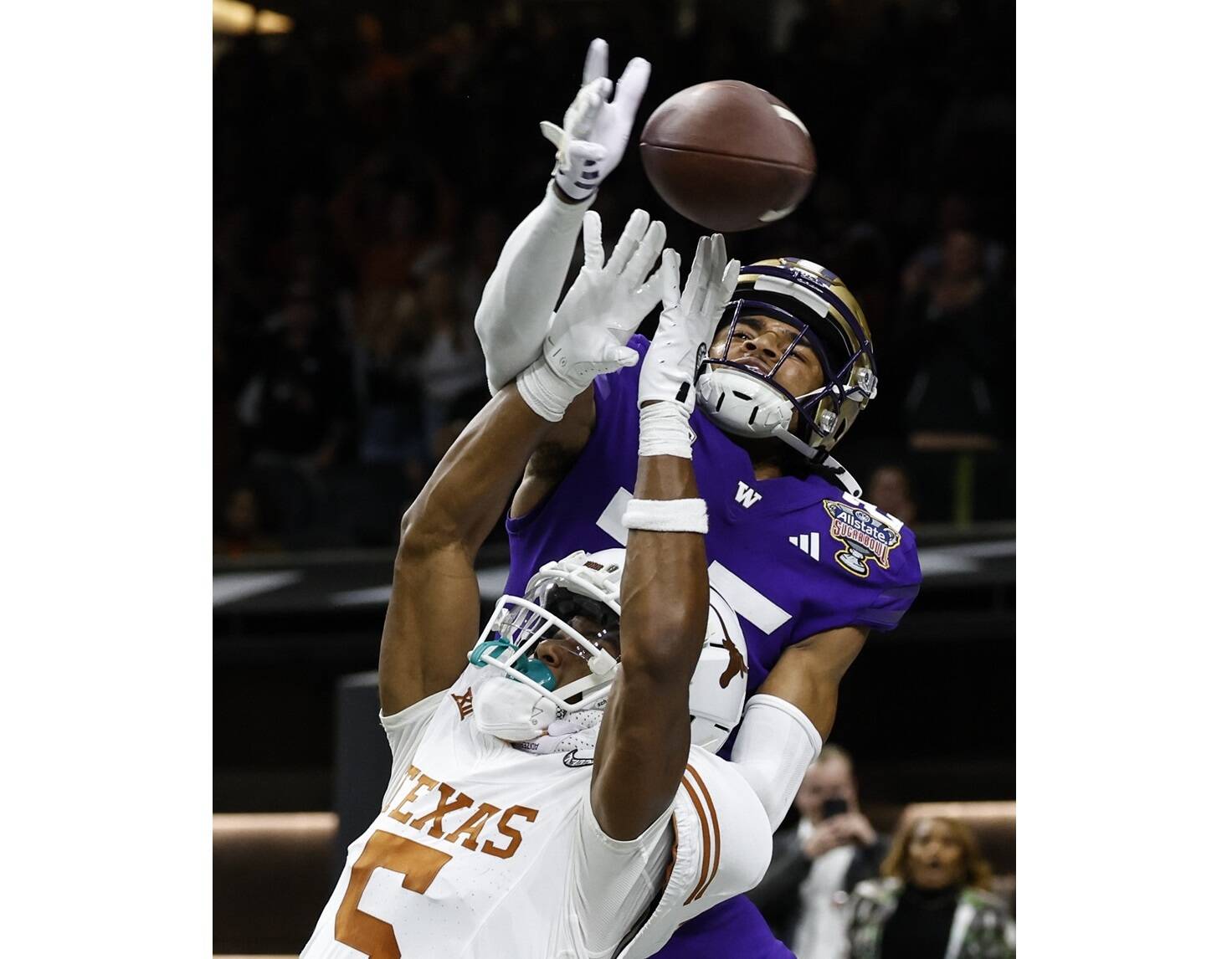 Washington cornerback Elijah Jackson (25) hits the ball before Texas wide receiver Adonai Mitchell (5) can catch it on the final play of the Sugar Bowl CFP NCAA semifinal college football game between Washington and Texas on Monday in New Orleans. Washington won 37-31. (AP Photo/Butch Dill)