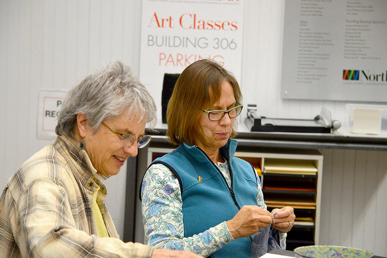 Glo Lamson, left, and a fellow artist worked on projects at a Northwind Art School open studio last year. Lamson will host another free creative studio this Saturday. (Northwind Art)