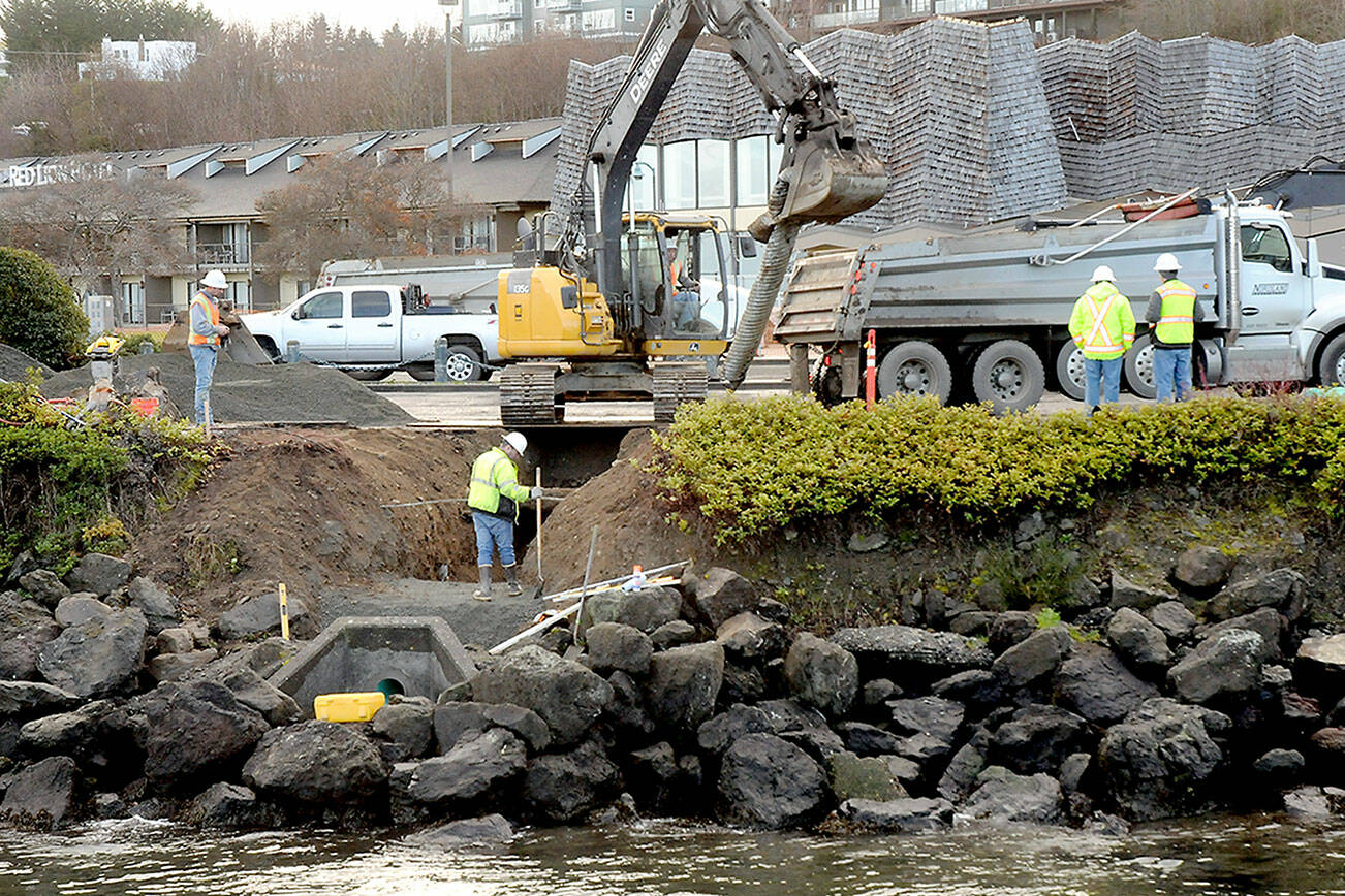 An excavator pulls a piece of aging stormwater drain pipe leading to the Peabody Creek Estuary under the parking lot at Port Angeles City Pier on Thursday. The operation was part of a project to replace a failed stormwater line, fortify the shoreline from erosion and replace damaged sidewalks around the parking area. In addition to the repairs, pedestrian ramps within the City Pier parking lot will be replaced and made ADA compliant. Nordland Construction, Inc. is the contractor for the city project. The parking lot, located at North Lincoln Street and East Railroad Avenue, is expected to remain closed through the project, which is expected to be completed in March. (Keith Thorpe/Peninsula Daily News)