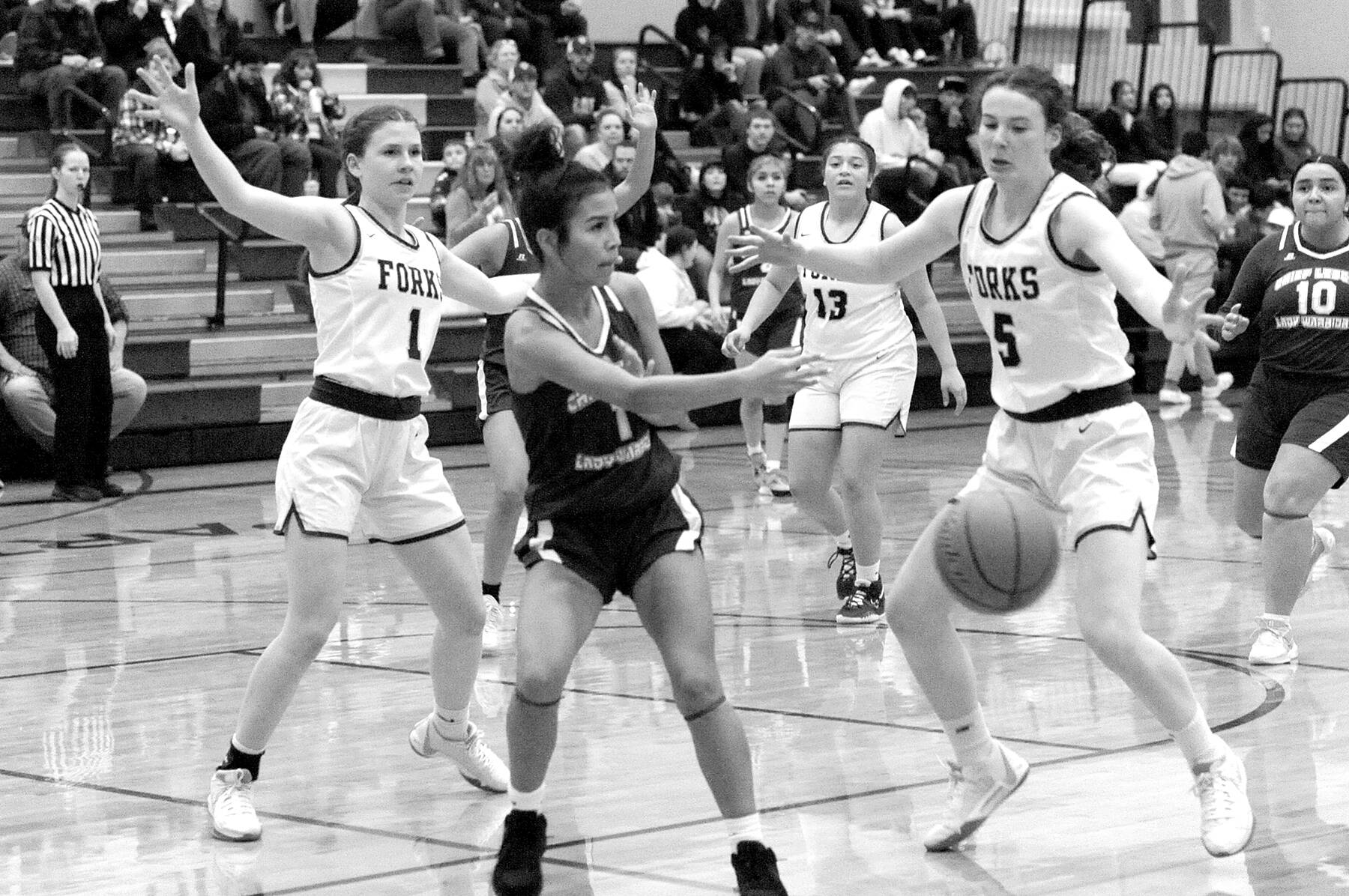 partan sisters Bailey Johnson (1) and Keira Johnson (5) get defensive against Chief Leschi in Forks where Forks defeated the Warriors 78 to 26.  Also in the action is Spartan Janessa Ramos (13).  Photo by Lonnie Archibald.