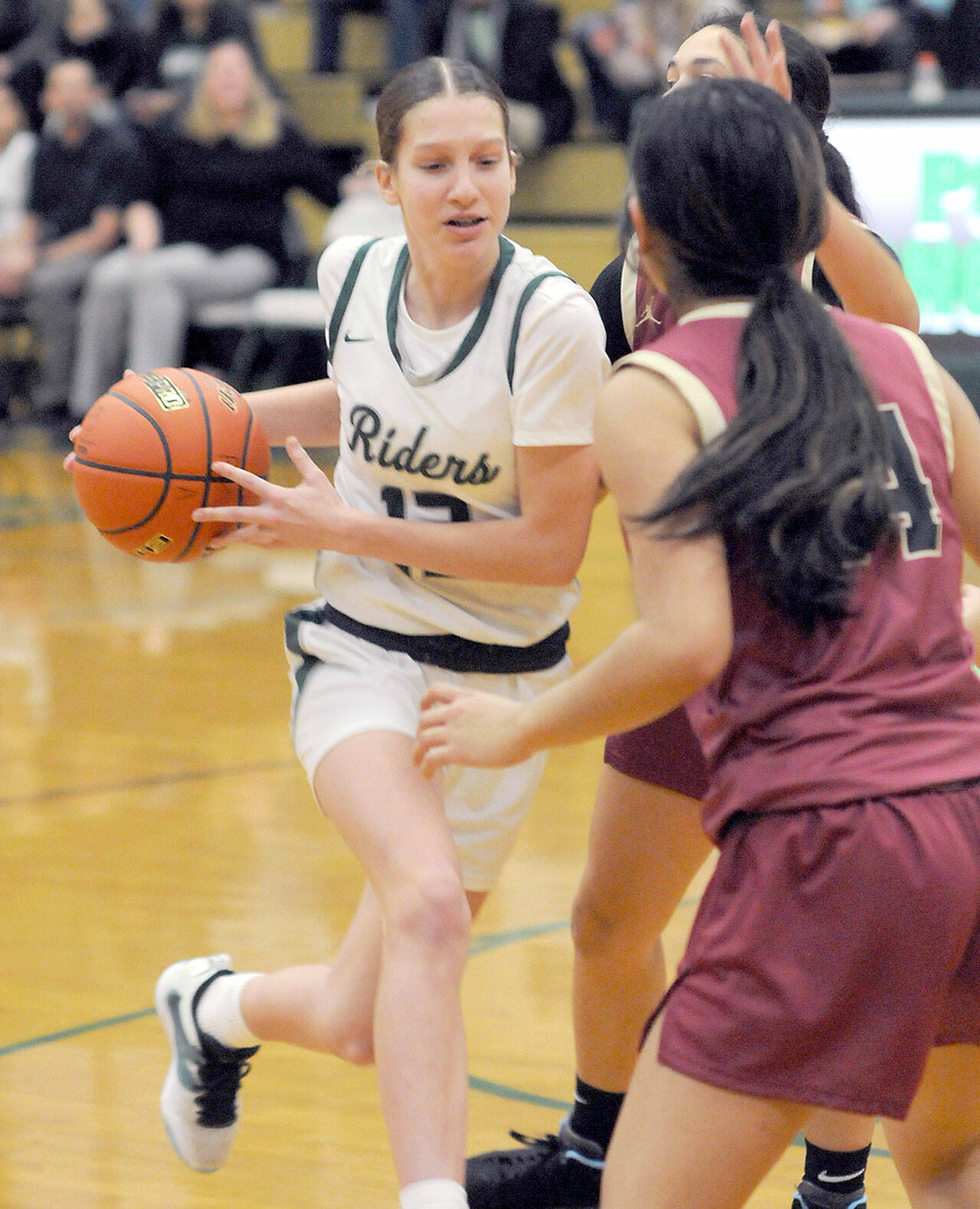 Port Angeles’ Morgan Politika, left, drives to the lane defended by Kingston’s Tati Fontes-Lawrence, right, on Tuesday night in Port Angeles. (Keith Thorpe/Peninsula Daily News)