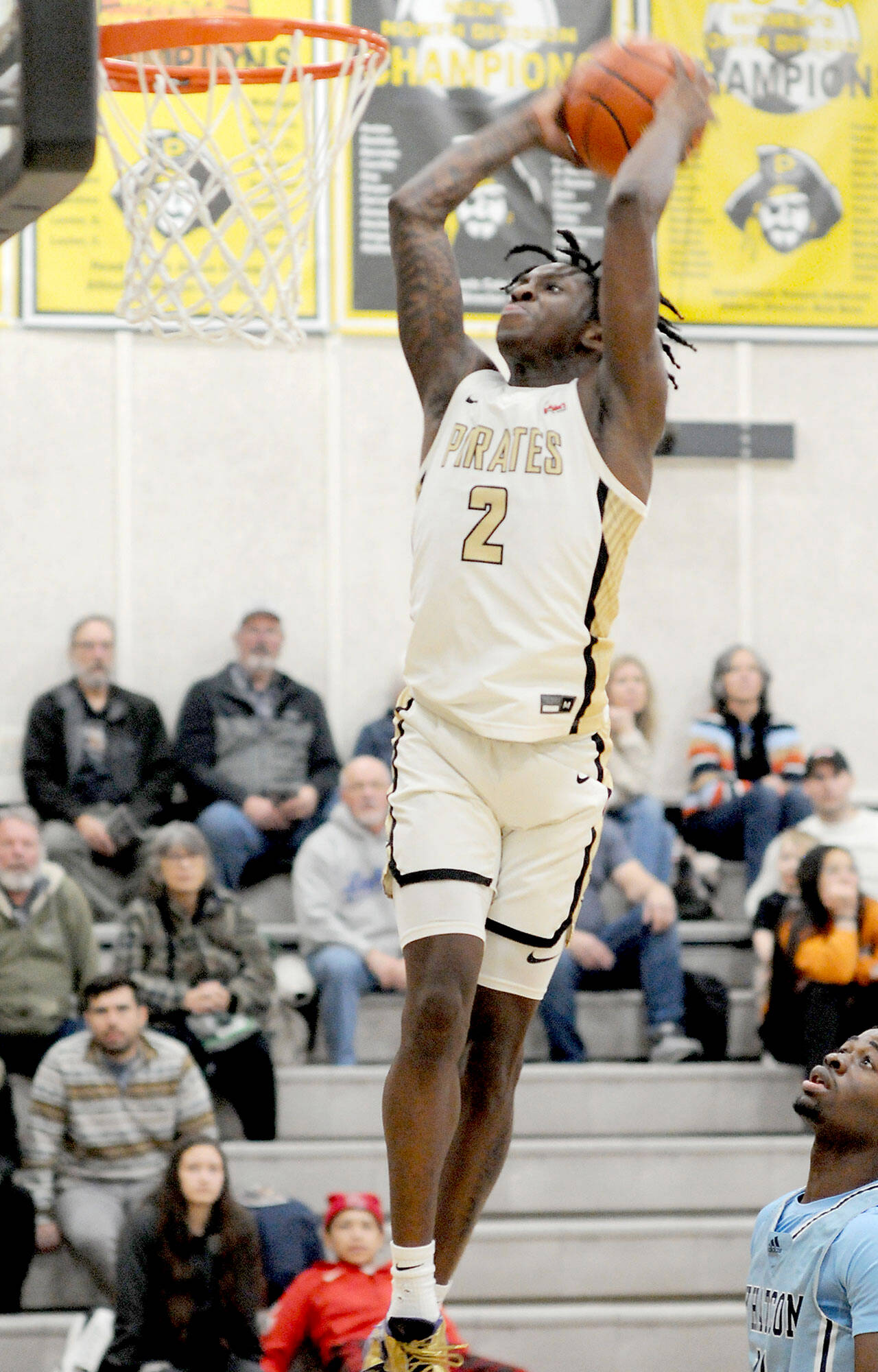 KEITH THORPE/PENINSULA DAILY NEWS Peninsula’s Ese Onakpoma makes a slam dunk after a quick steal against Whatcom on Wednesday evening in Port Angeles. Looking on is Whatcom’s Glenn Wabaluku.