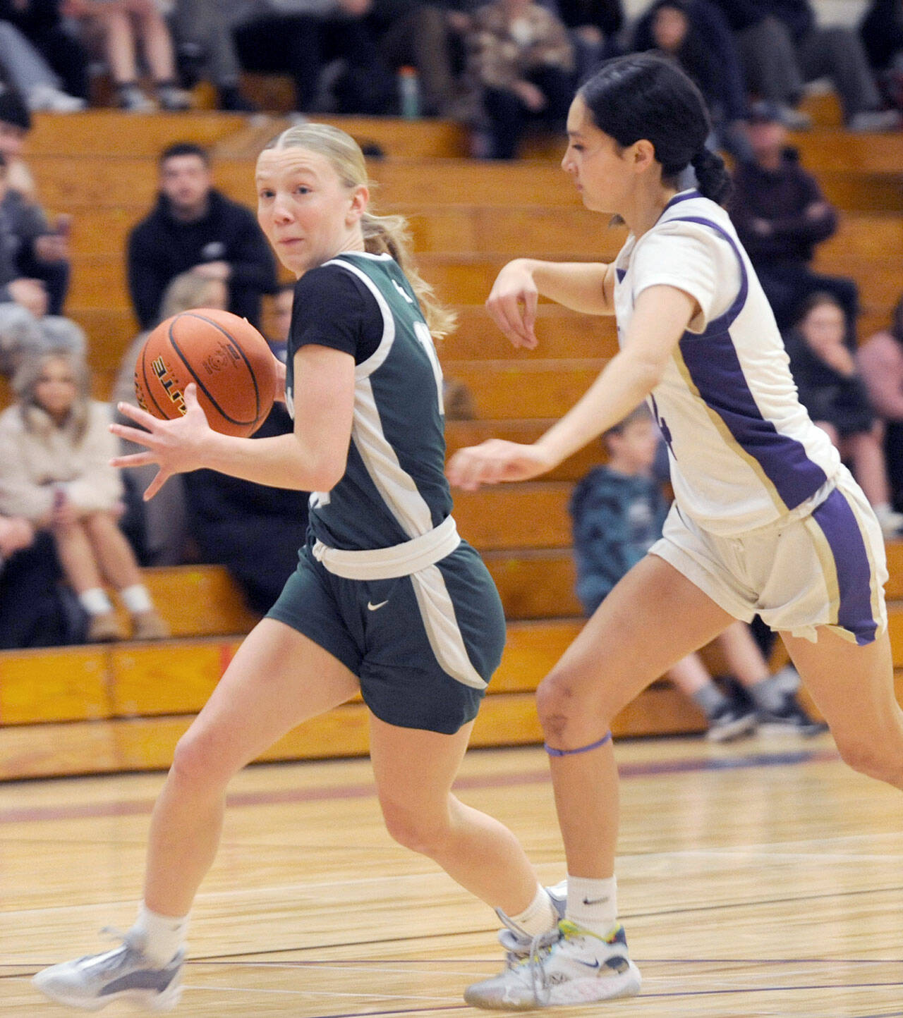 Michael Dashiell/Olympic Peninsula News Group Port Angeles’ Izzy Felton dribbles around the defense of Sequim’s Gracie Chartraw during the Riders’ 66-64 Rainshadow Rumble rivalry win over the Wolves on Thursday.