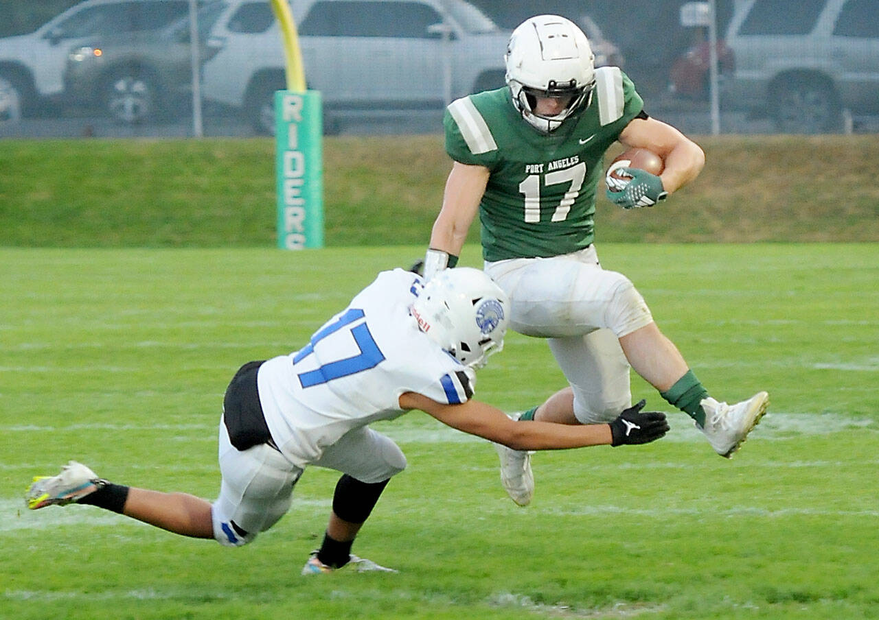 Port Angeles’ Jason Hawes, right, evades the tackle of Olympic’s Donovan Weaver in a game in October at Port Angeles Civic Field. (Keith Thorpe/Peninsula Daily News)
