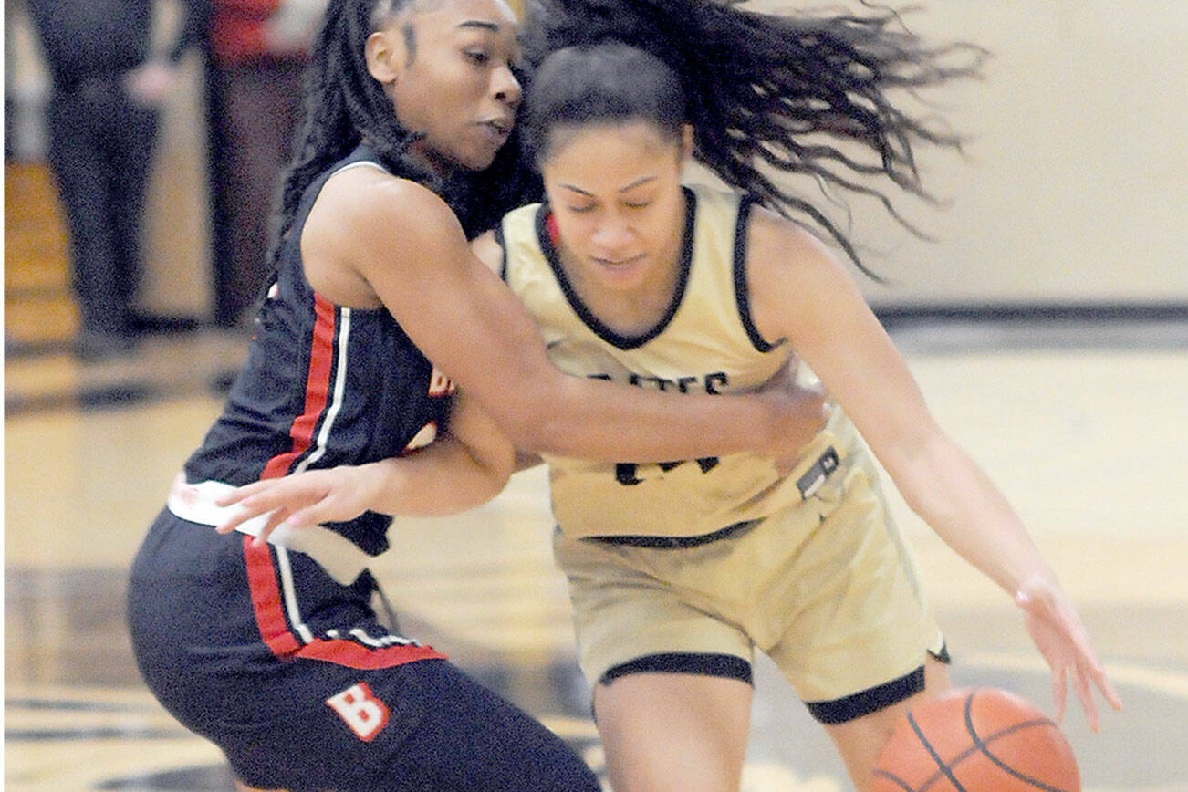 Peninsula’s Shania Moananu, right, is held by Bellevue’s Alicia Morrison on Wednesday night at Peninsula College. (Keith Thorpe/Peninsula Daily News)