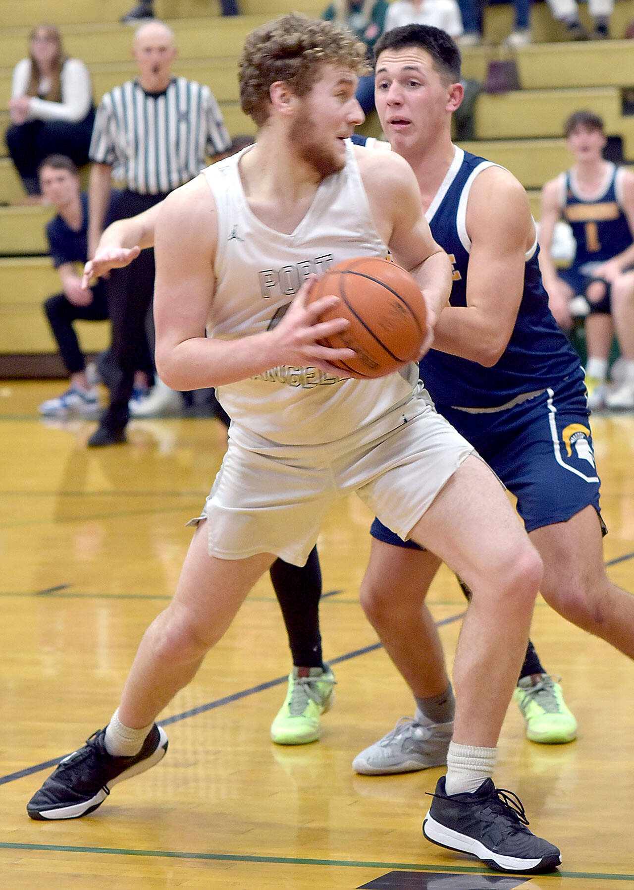 KEITH THORPE/PENINSULA DAILY NEWS Port Angeles’ Isaiah Shamp, front, picks his path to the lane as Bainbridge’s Will Rohrbacher tries to hold him off on Thursday in Port Angeles.