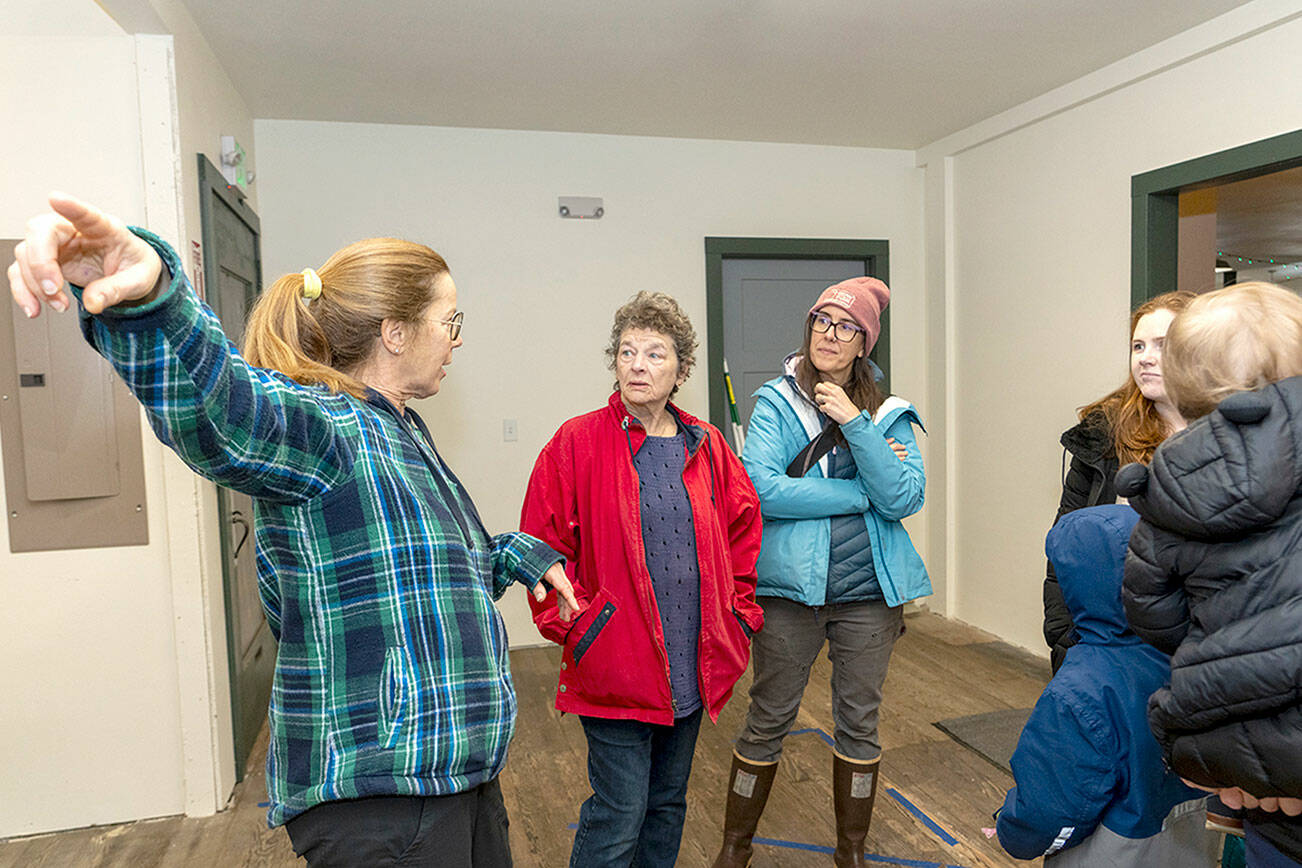 Nordland General Store Co-op CEO Patti Buckland, left, points to an area of the store to a group of visitors at the open house on Saturday in Nordland on Marrowstone Island. (Steve Mullensky/for Peninsula Daily News)