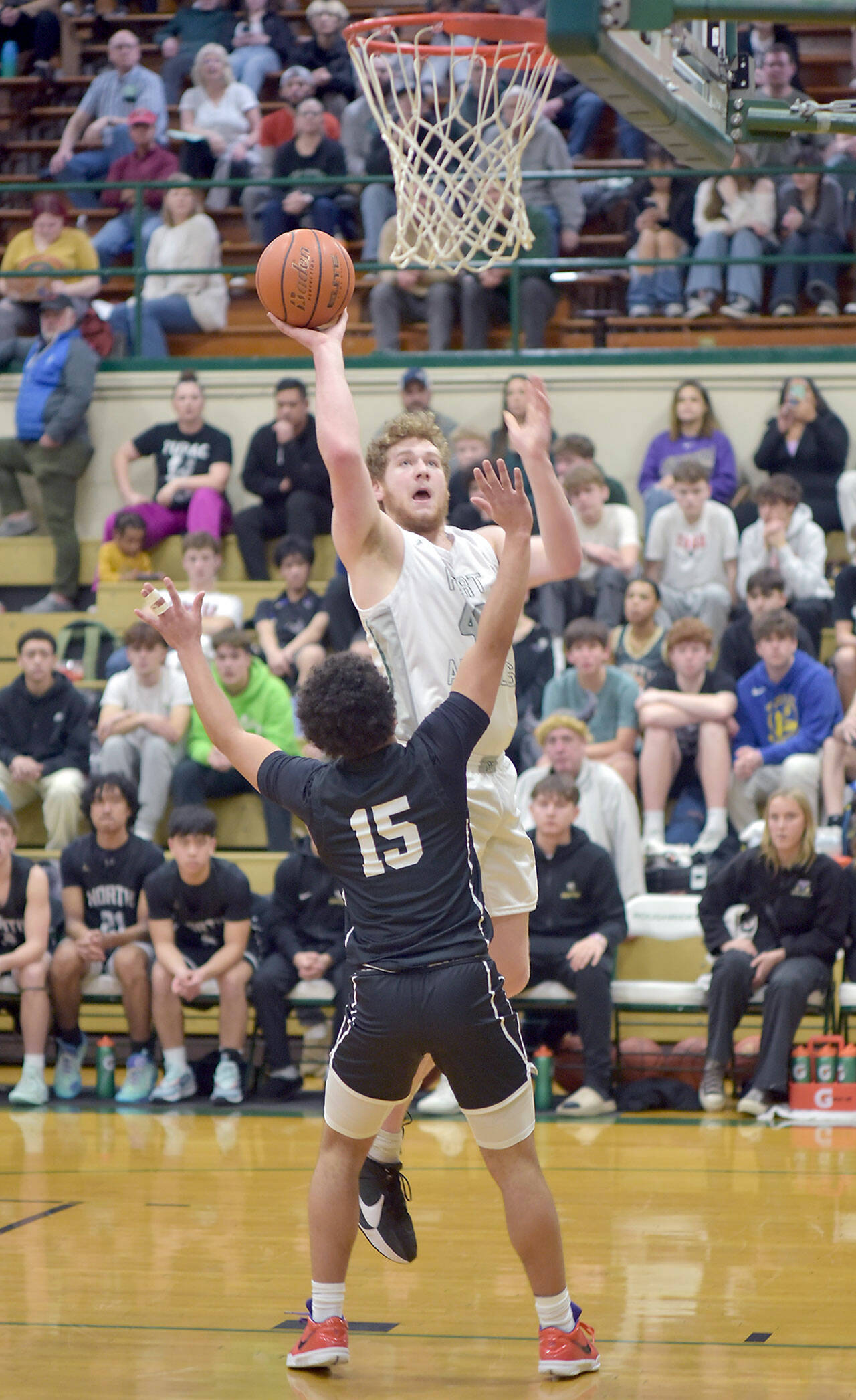 Port Angeles’ Isaiah Shamp aims for the rim as North Kitsap’s Jordan Williams defends the lane on Tuesday night at Port Angeles High School. (Keith Thorpe/Peninsula Daily News)