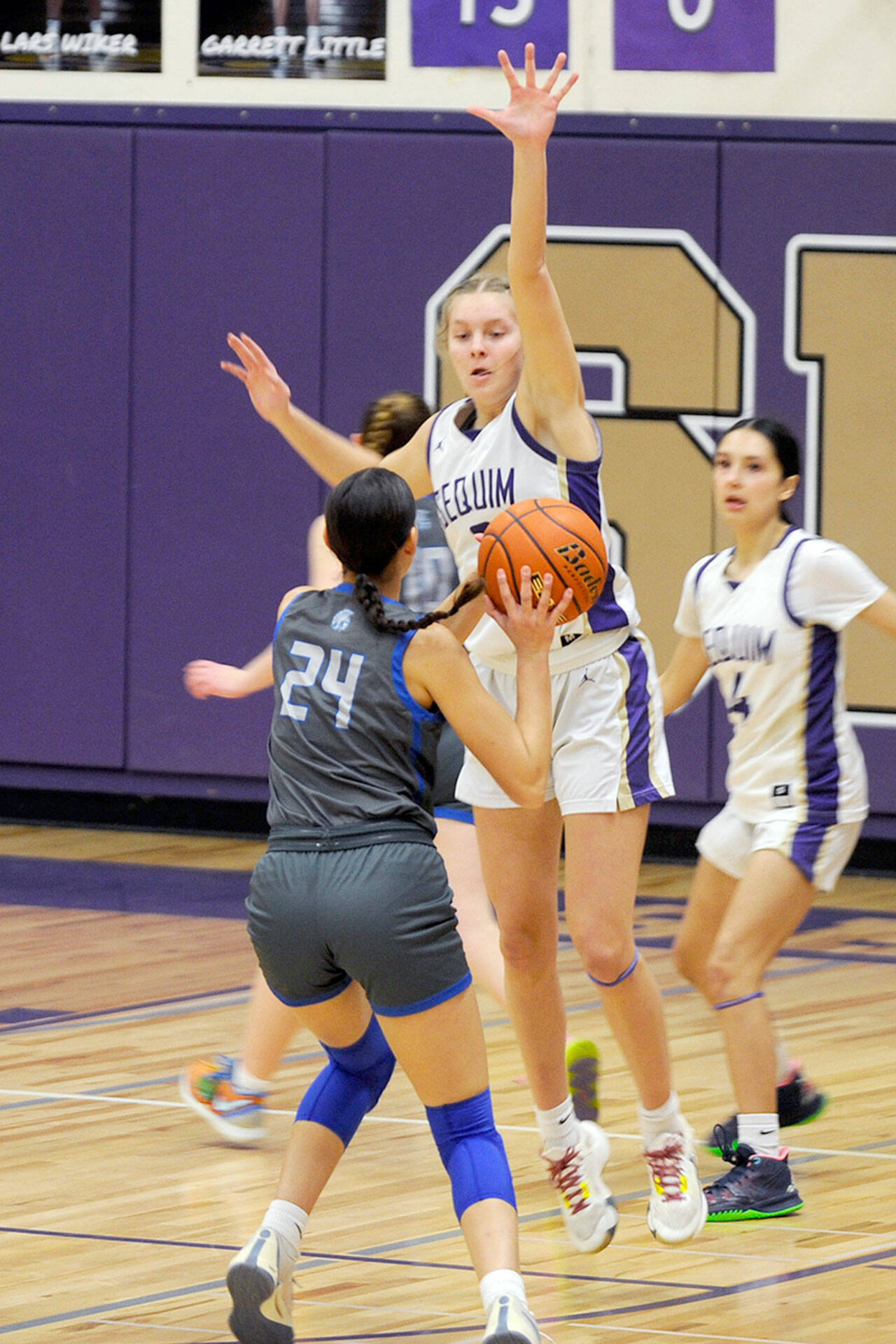Matthew Nash/Olympic Peninsula News Group Sequim’s Jolene Vaara defends a shot taken by Olympic’s Sophia Brown as the Wolves’ Gracie Chartraw looks on during Sequim’s 81-44 win Thursday.