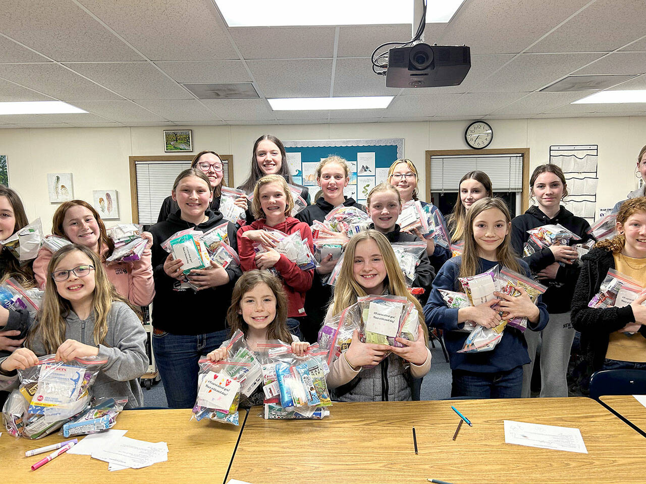 Neon Riders 4-H club members gathered together to make care packages filled with food, soaps, toothbrushes and cheery notes they gave to local charity’s that help those displaced from their homes. (Submitted photo by Lila Torey0)