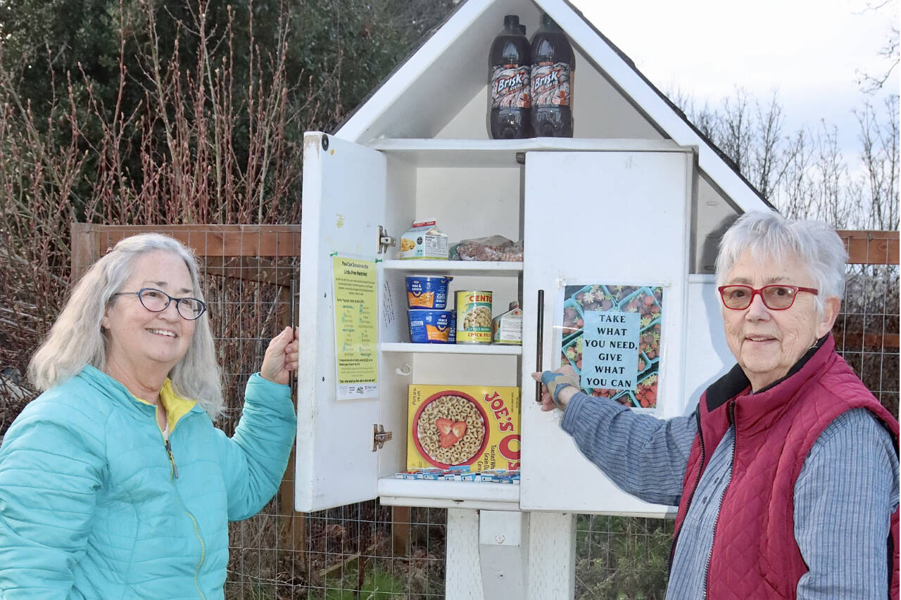 Dave Logan/For Peninsula Daily News
Martha Bell, left, and Nancy Jacobson put new donations into the Little Free Pantry box at 316 S. Cherry St. that is sponsored by First Presbyterian Church in Port Angeles.