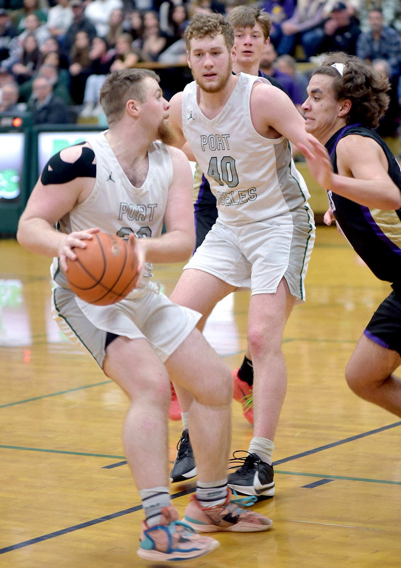 KEITH THORPE/PENINSULA DAILY NEWS 
Port Angeles' Ezra Townsend, left, looks for an opening as teammate Isaiah Shamp, center, holds off Sequim's Lars Wiker on Tuesday in Port Angeles.