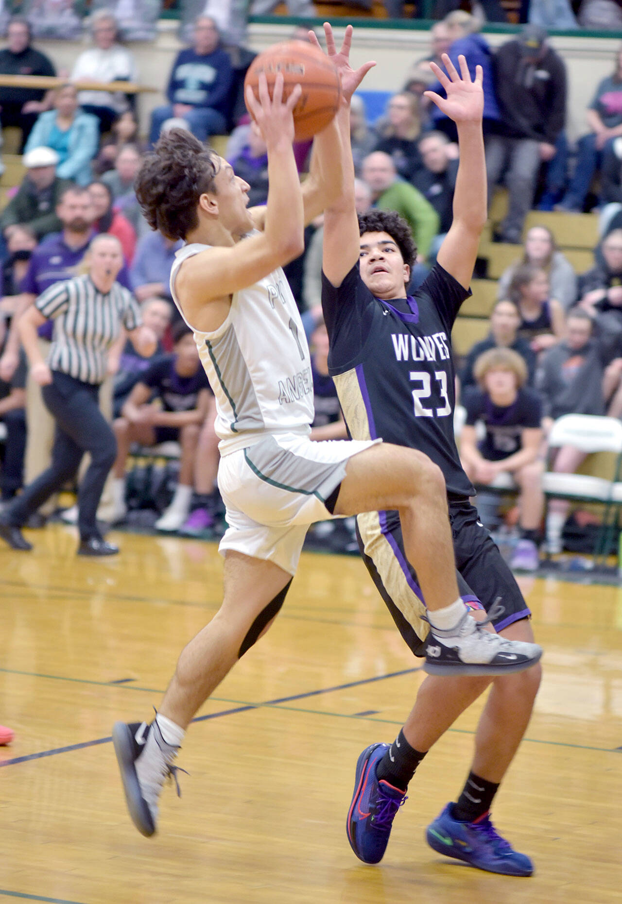 KEITH THORPE/PENINSULA DAILY NEWS Port Angeles’ Kason Albaugh, left, looks for the layup as Sequim’s Jerico Julmist defends the lane on Tuesday at Port Angeles High School.